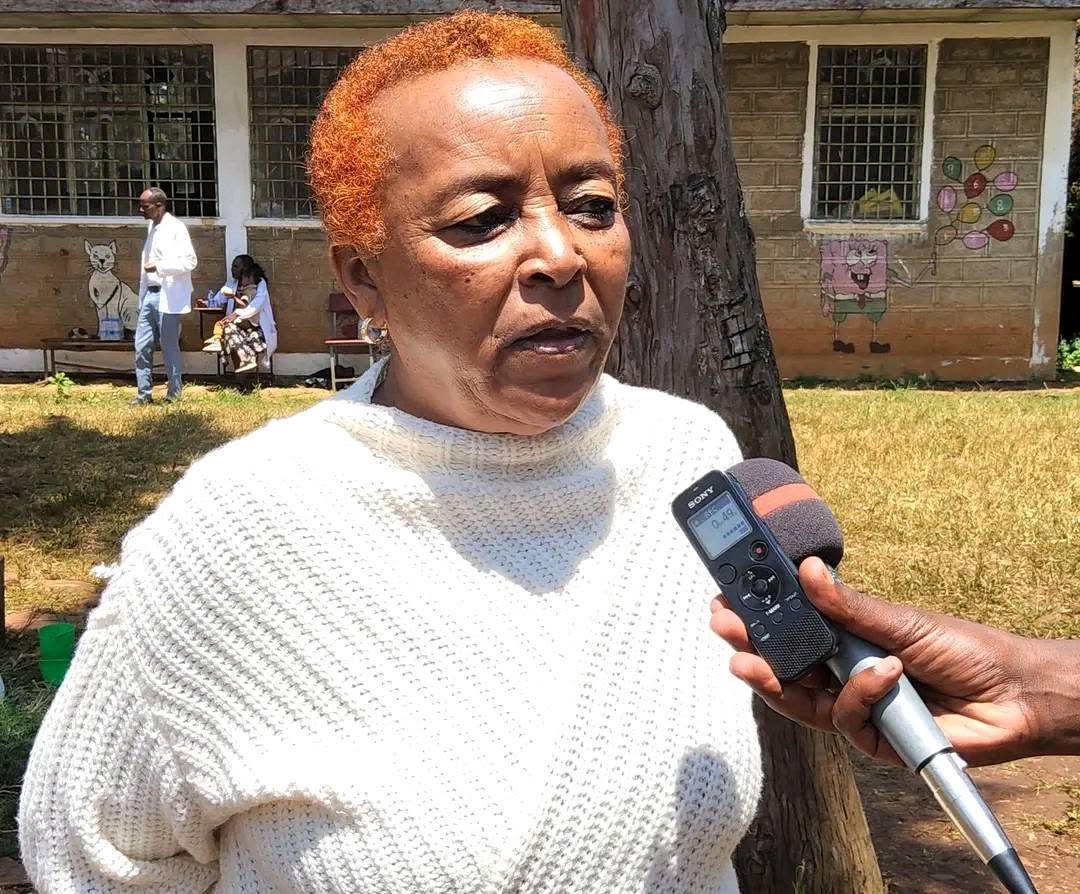 A woman speaking into a microphone at the community event