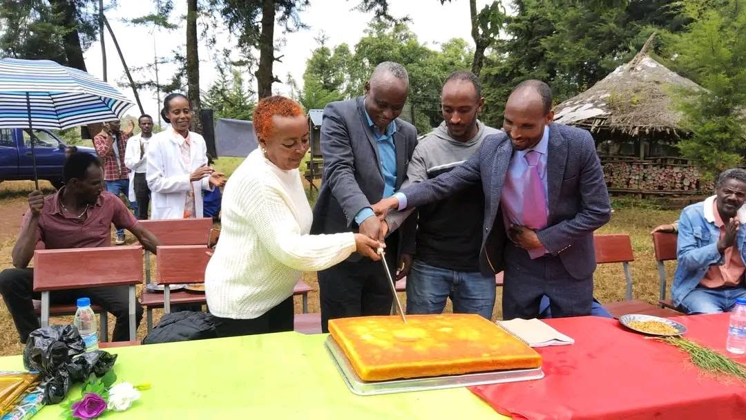 Adults gathered around a cake at the community event