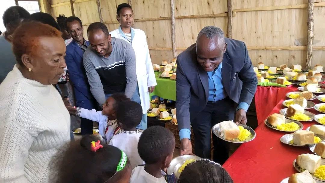 Adults serving food to children