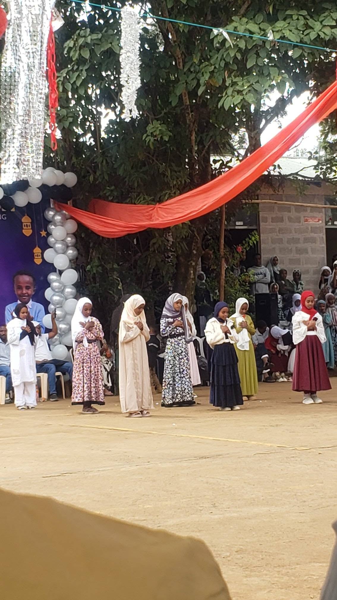 Children lined up on stage at the Eid celebration