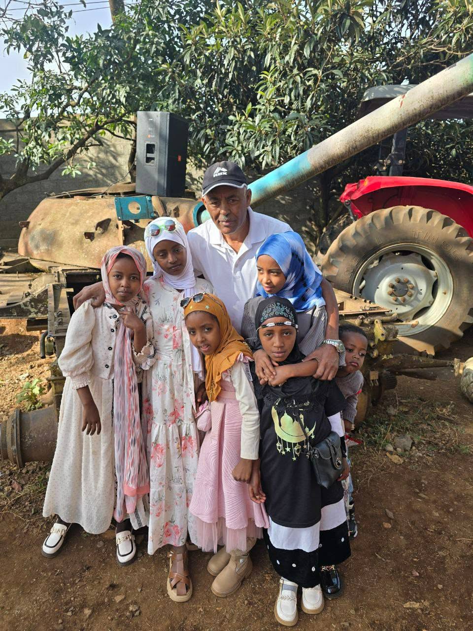 Children and an adult posing outdoors during the Eid celebration