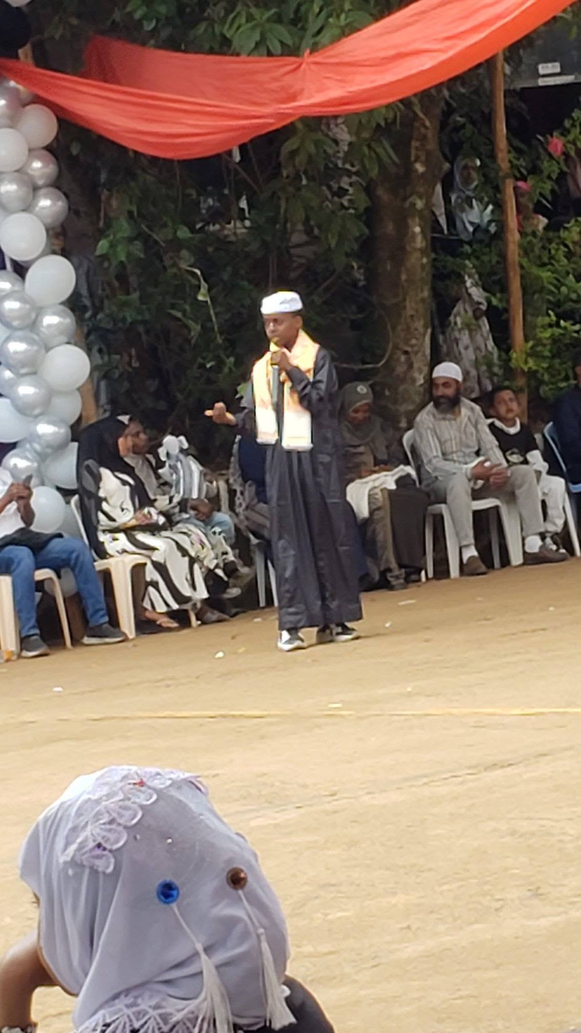 A speaker holding a microphone at the Eid celebration