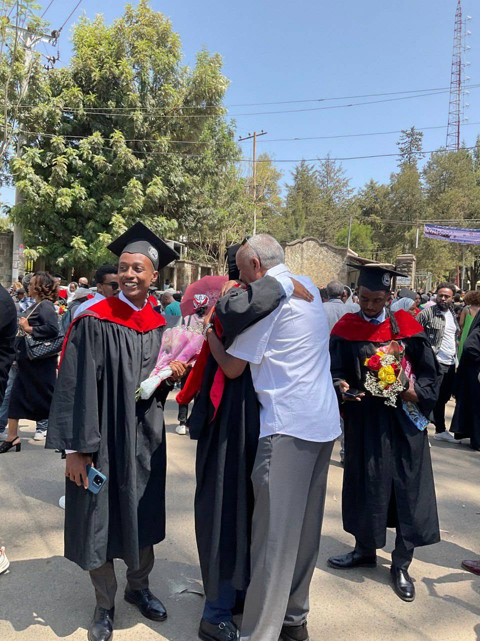 Graduates and adults together at the outdoor graduation celebration